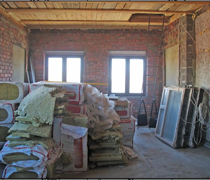 room with brick walls and insulation stacked in the room