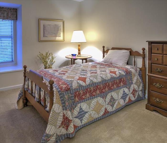 bedroom with quilted bed and a dresser