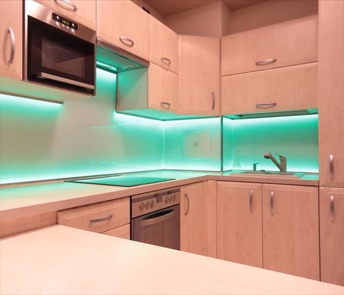 kitchen with white cabinets and lighting around the backsplash