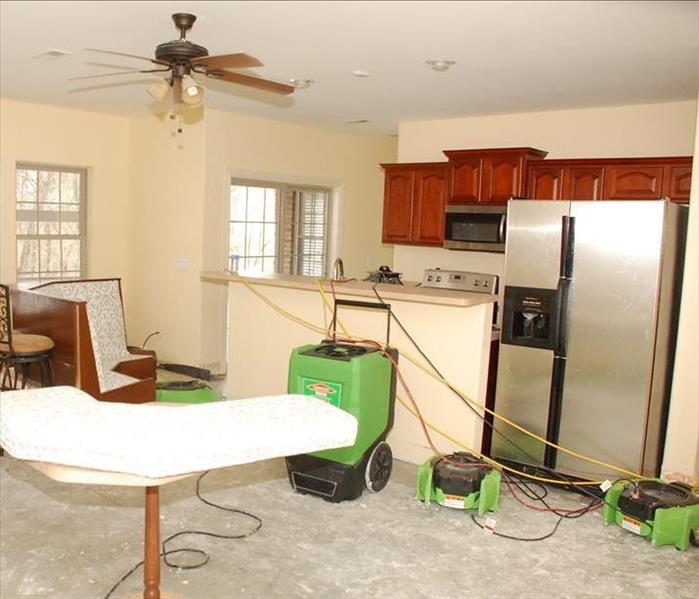 kitchen with concrete subfloor and green SERVPRO equipment setup