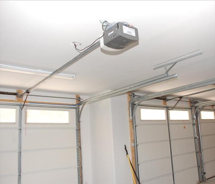 white garage with a garage door opener on the ceiling
