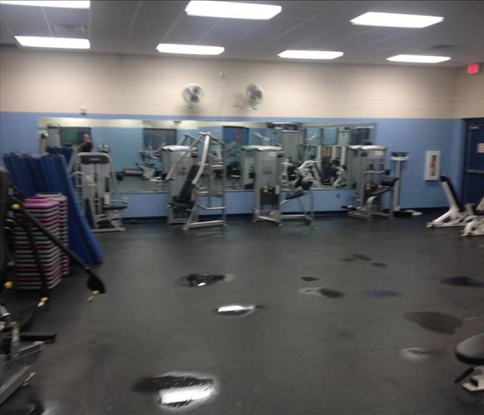 gym with equipment and water pooling in spots on the ground