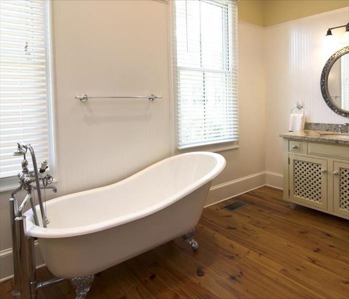 bathroom with white free standing tub and hardwood flooring