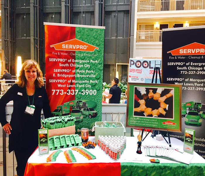 employee standing by a table with SERVPRO promotional items