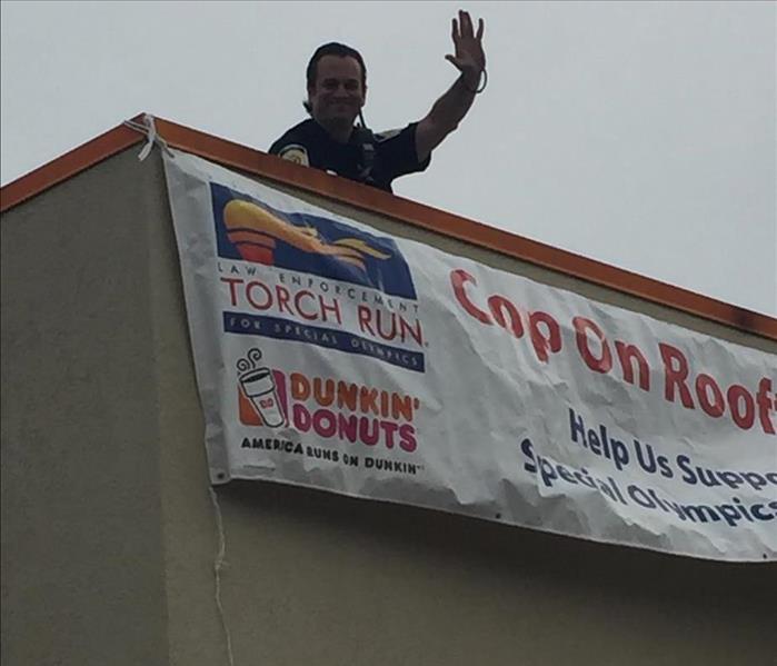 officer waving from on top of a building