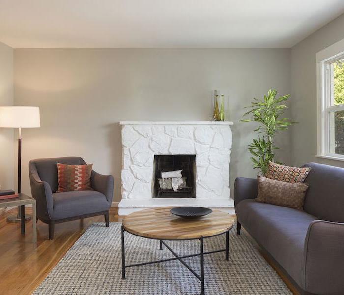 living room with white stone fireplace and grey furniture