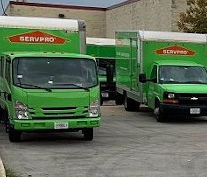 Two SERVPRO trucks in a parking lot 
