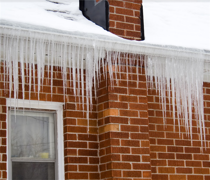a snow covered roof with icicles hanging off of the gutters