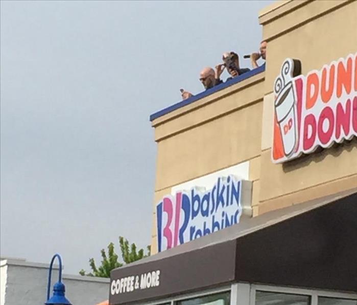 officers on top of Dunkin Donuts and Baskin Robbins building
