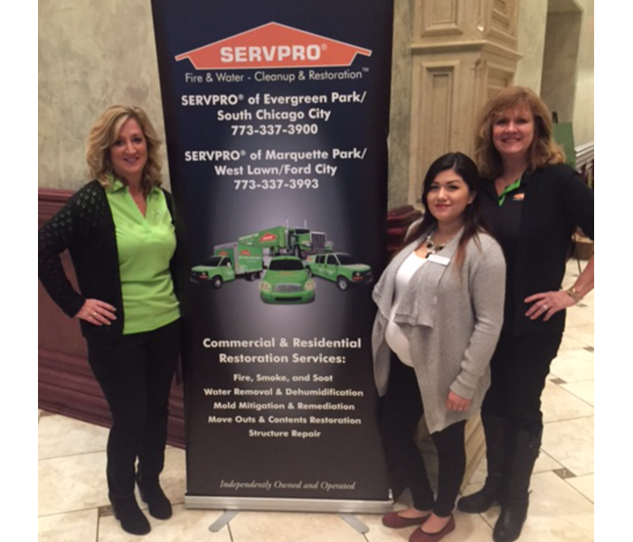 2 females standing next to a large SERVPRO sign