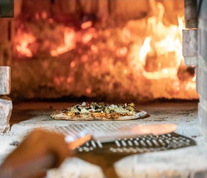 pizza oven with flames in the background