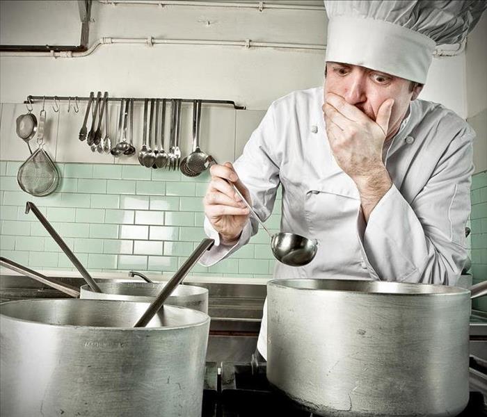 chef holding a spoon over a pot