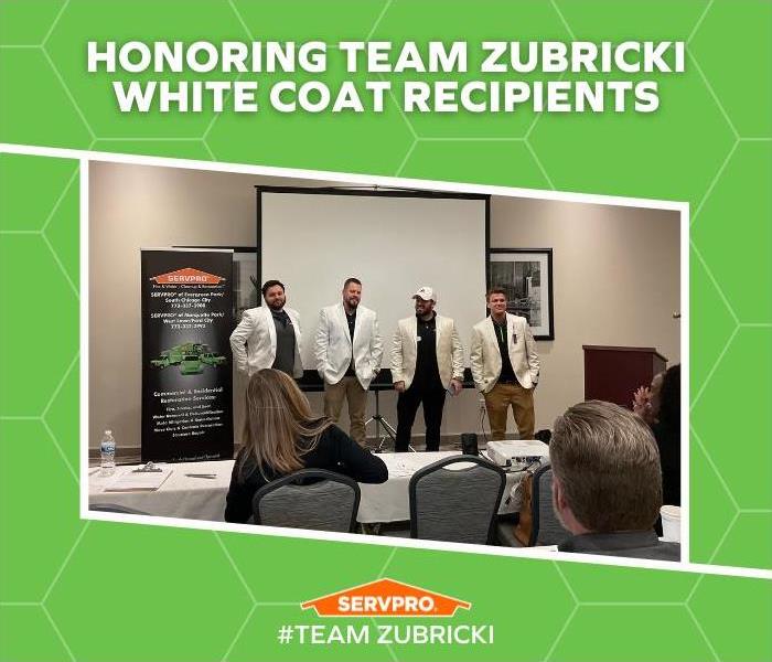 4 employess wearing white coats in a training room