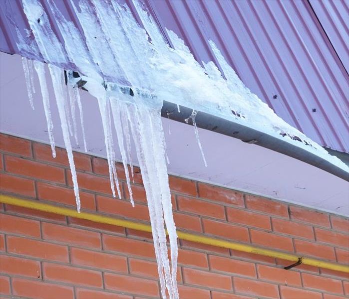 water frozen in gutter; icicles and ice on roof